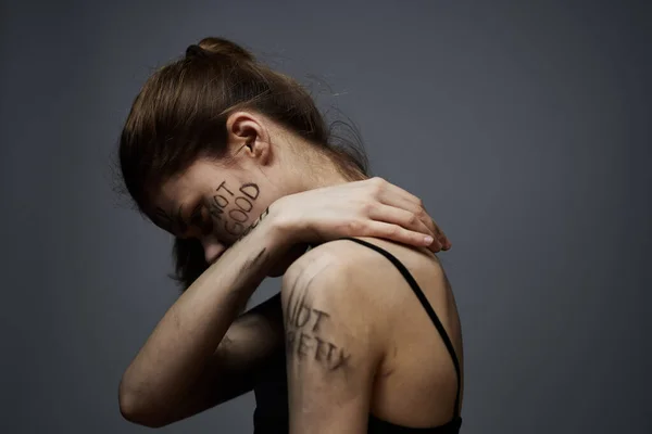 Mujer con inscripciones ofensivas en su cuerpo tocándose con las manos estrés frustración odio —  Fotos de Stock