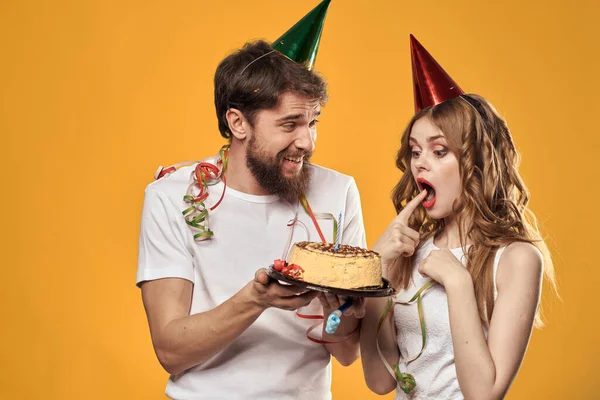 Erkek ve kadın doğum günü şenlikli pasta sarı arka plan ve başlıklar — Stok fotoğraf