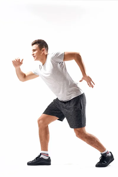 Спортивный человек на светлом фоне в полный рост и бег трусцой зарядки кроссовки кроссовки — стоковое фото