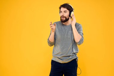 Kulaklıklı bir adam müzik, yaşam tarzı teknolojisi, sarı arka plan.