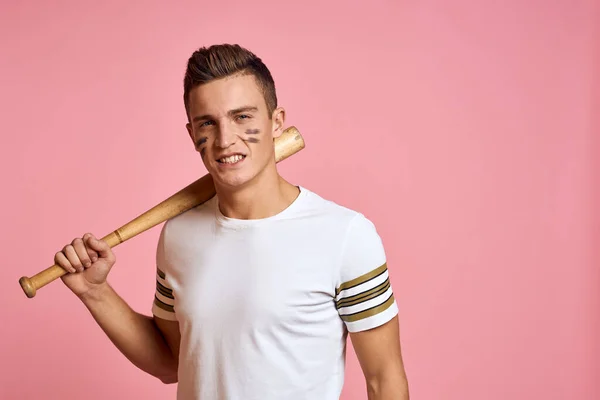 Energetic man with a bat on a pink background T-shirt face make-up black lines aggression model — Stock Photo, Image