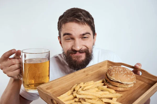 Homme avec plateau en bois tasse de bière frites et hamburger fast food calories modèle t-shirt blanc — Photo