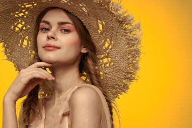 Şapkalı ve elbiseli bir bayan. Kızıl saçlı, sarı arka planlı, model portresi eğlenceli.