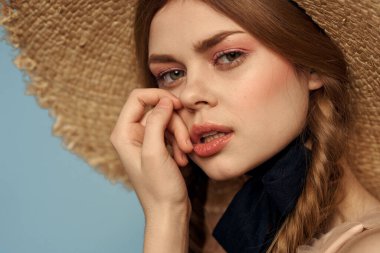 Hasır şapkalı kız portresi yakın çekim at kuyruğu eğlenceli kızıl saçlı mavi arka plan