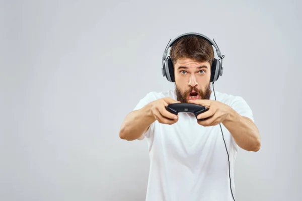 Mann im Kopfhörer mit Gamepad spielt Hobby Unterhaltung Lifestyle Licht Hintergrund — Stockfoto