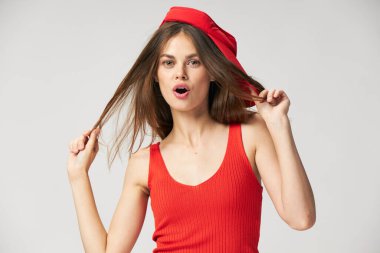 Ağzı açık, saçları kırmızı şapkalı bir kadın ileriye bakıyor. 