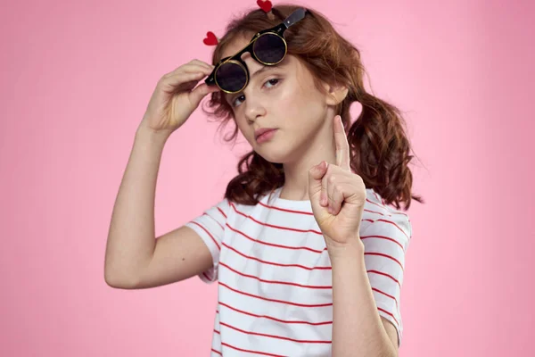 可爱的女孩太阳镜条纹T恤生活方式有趣的粉色背景 — 图库照片
