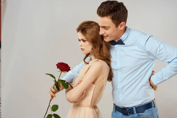 Vidám fiatal pár romantika ölelés kapcsolat piros rózsa életmód fény háttér — Stock Fotó