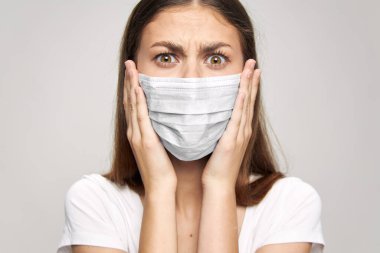 Tıbbi maske hoşnutsuz. Yüze yakın ellere bak. 