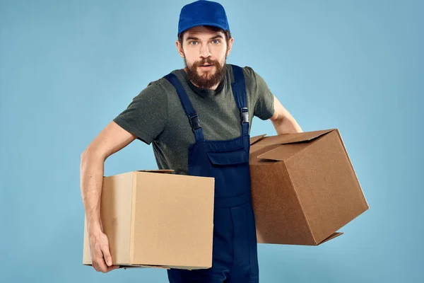 Trabalho homem caixas em mãos entrega serviço embalagem estilo de vida azul fundo — Fotografia de Stock