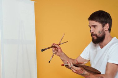 Erkek sanatçı palet resim sehpası hobi yaşam tarzı yaratıcılık sarı arka plan