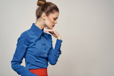 Mavi gömlekli zarif bir bayan, elleri arka planda ve yakın plan bir fotokopi portresiyle hareket ediyor.