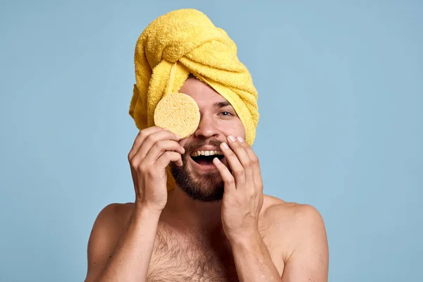 Een man met een gele handdoek op zijn hoofd kont blote schouders schone huid neemt een douche — Stockfoto