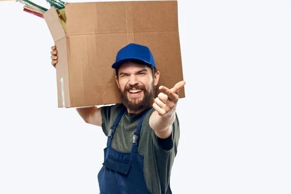 Ein Mann in Arbeitsuniform mit einer Schachtel in der Hand liefert Transportarbeiten aus — Stockfoto