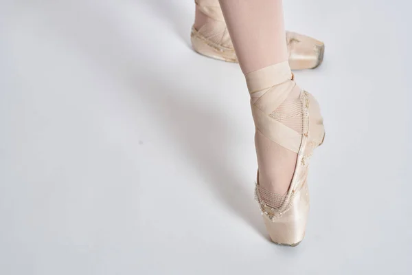 Балерина в белой балетной пачке исполняется на светлом фоне — стоковое фото