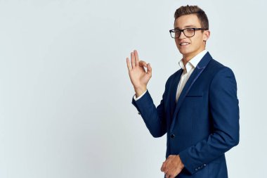 Gözlüklü bir iş adamı mavi takım elbiseli resmi ışık arkaplanı kesmiş.