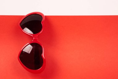 Kalp şekilli güneş gözlüğü ve kırmızı arkaplan kopyalama alanı