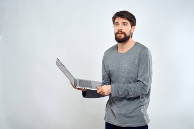 Elinde dizüstü bilgisayar, iletişim, yaşam tarzı teknoloji ışık arka plan stüdyosu tutan bir adam.