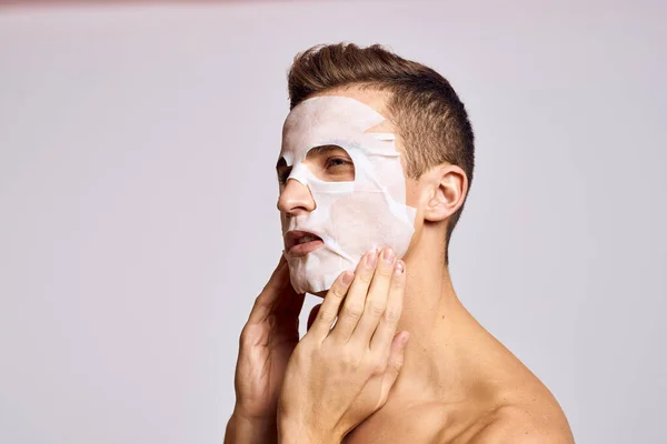 man with cleansing mask on face against black dots on isolated background cropped view