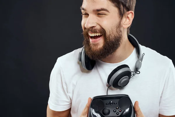 Man met joystick in handen koptelefoon technologie vrijetijdsbesteding spel levensstijl donker geïsoleerde achtergrond — Stockfoto