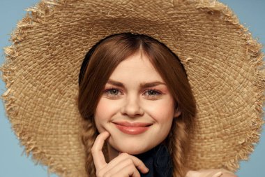 Hasır şapkalı kız portresi yakın çekim at kuyruğu eğlenceli kızıl saçlı mavi arka plan