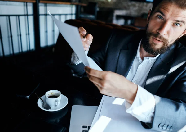 Uomo d'affari in un tailleur davanti a laptop emozioni documenti ufficiali tecnologia — Foto Stock