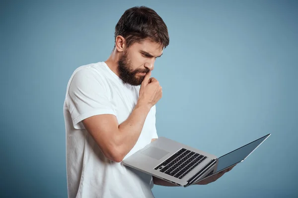 Емоційний чоловік з ноутбуком в руках на синьому фоні монітор клавіатури Інтернет-модель обрізаний вид — стокове фото