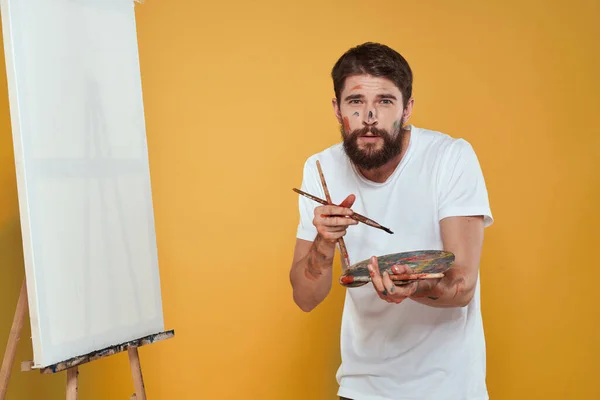 Artista masculino paleta caballete dibujo hobby estilo de vida creatividad amarillo fondo — Foto de Stock