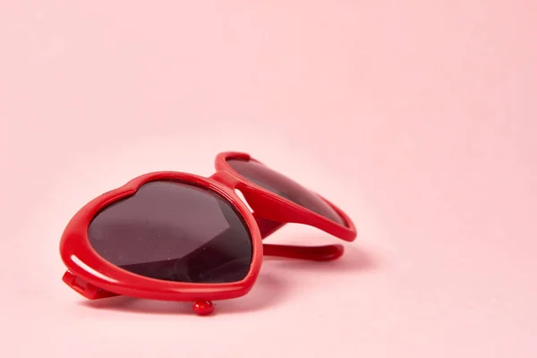 Gafas de sol en forma de corazón con monturas rojas sobre fondo rosa —  Fotos de Stock