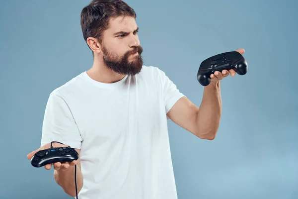 Vrolijke man met joysticks in handen lifestyle vrije tijd blauwe achtergrond — Stockfoto