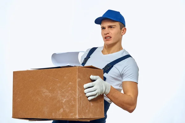 Homme travailleur avec boîte dans les mains livraison chargement service lumière arrière-plan — Photo