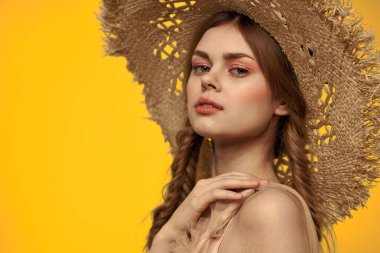 Şapkalı ve elbiseli bir bayan. Kızıl saçlı, sarı arka planlı, model portresi eğlenceli.