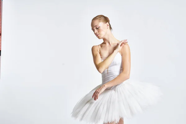 Bailarina en un tutú blanco realizando ejercicio de danza flexibilidad fondo claro —  Fotos de Stock