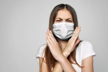 Yüzünde tıbbi maske olan bir kadın kollarını kavuşturdu. 