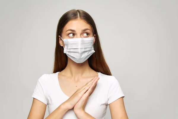 Девушка Медицинская маска на лице, посмотрите на сторону белой футболки — стоковое фото
