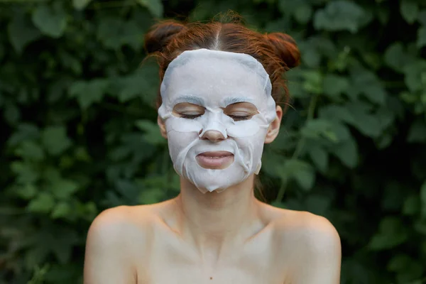 Menina agradável máscara anti-envelhecimento olhos fechados e um sorriso não natural pele clara — Fotografia de Stock