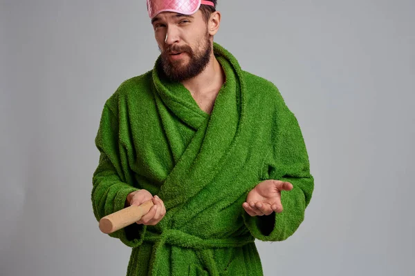 Man with rolling pin in hand green robe pink sleep mask cropped view — Stock Photo, Image