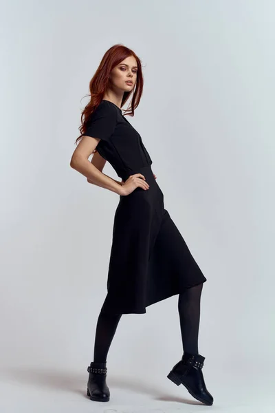 Жінка в чорній сукні на світлому фоні і колготки взуття руде волосся і позу в повному зростанні — стокове фото