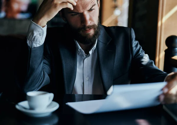 Homme d'affaires assis à une table dans un café documents travailler tasse de café officielle — Photo