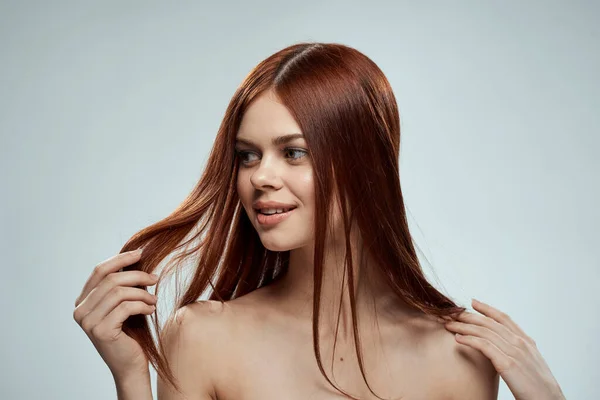 아름다운 붉은 머리 여인의 벗은 어깨에는 화장품이 달린 긴 머리 유리, 밝은 배경 — 스톡 사진