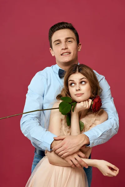 Retrato de casal romântico apaixonado por rosa vermelha em fundo isolado e vestido de noite terno clássico — Fotografia de Stock
