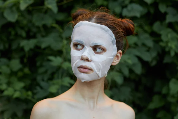 Krásná žena kosmetická maska omlazovací keře v pozadí — Stock fotografie