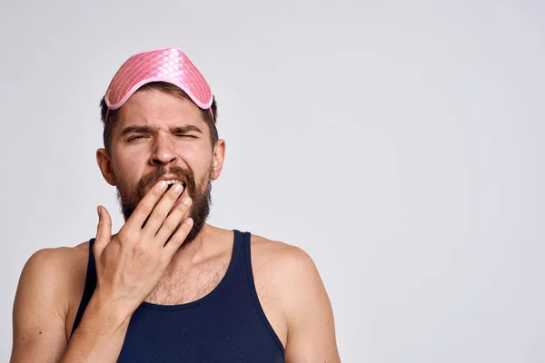 Ein Mann mit pinkfarbener Schlafmaske und schwarzem T-Shirt auf grauem Hintergrund hat die Sicht verstellt. — Stockfoto