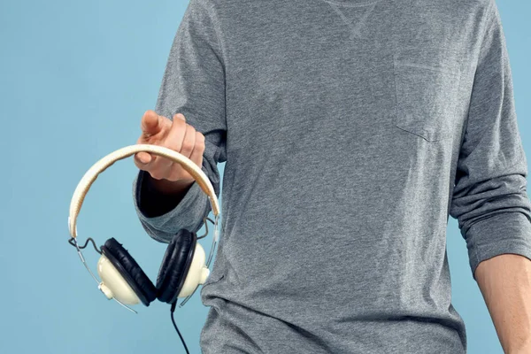 Sluchátka v mužských rukou oříznutý pohled hudební technologie modré pozadí — Stock fotografie
