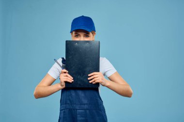 İş formunda çalışan bir kadın hizmet bürosunun geçmişini mavi yapıyor.