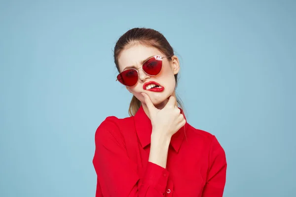 Mulher bonita em óculos escuros camisa vermelha maquiagem brilhante emoções atraente olhar azul fundo — Fotografia de Stock