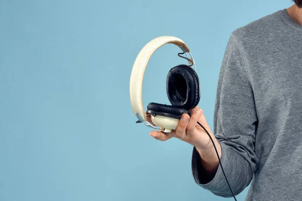 Auriculares en el hombre manos recortadas ver música tecnología fondo azul —  Fotos de Stock