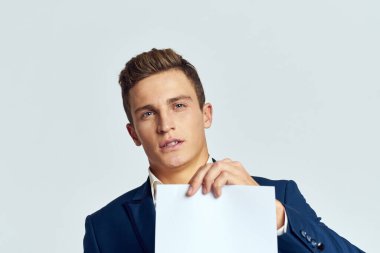 Takım elbiseli bir iş adamı resmi bir yöneticinin elinde bir kağıt tutuyor.