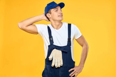 Çalışan üniformalı adam duygularını servis hizmeti sarı arka planda sunuyor
