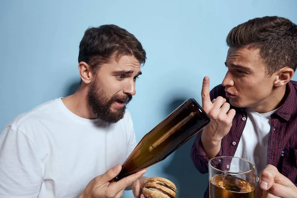 İki neşeli sarhoş arkadaş mavi bir arka planda bira içiyorlar. — Stok fotoğraf